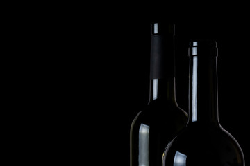 Two bottles of wine on black background close up
