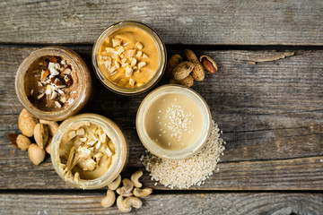 Selection of nut butters - peanut, cashew, almond and sesame seeds, copy space