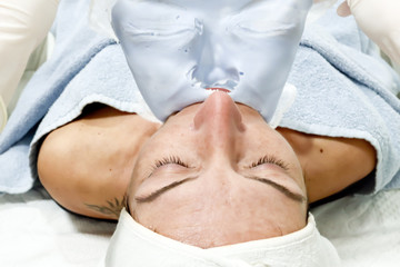 beautician worker removing cosmetic Caviar peel off mask for facial skin care  from a beautiful...