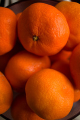bright, orange tangerines in a vase on a table