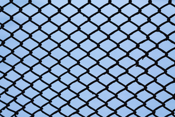 Silhouette of a metal lattice from a fence