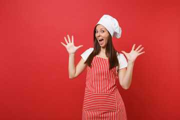 Housewife female chef cook baker in striped apron, white t-shirt, toque chefs hat isolated on red wall background. Shocked mad crazy fun housekeeper woman spreading hands. Mock up copy space concept.