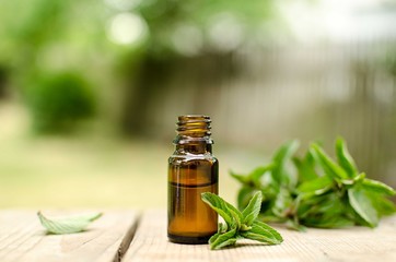 Natural Mint Essential Oil in a Glass Bottle with Fresh Mint Leaves