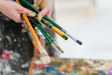 Artist's tools on the easel. Brushes, paints and canvas.