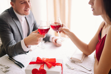 Valentine's Day concept. Happy couple in love with. A young loving couple celebrating Valentine's Day in the restaurant. Lovers give each other gifts. Romance restaurant for Valentine's Day- concept.