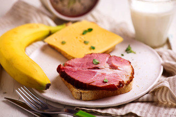 Cheese and ham sandwiches and  milk.Healthy breakfast.