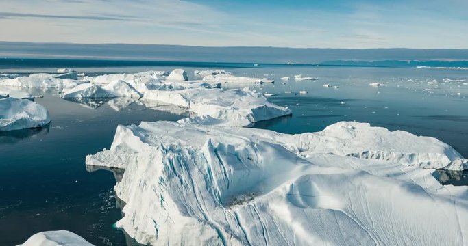 Iceberg aerial drone video - Global warming and climate change concept. Giant icebergs in Disko Bay on greenland in Ilulissat icefjord from melting glacier Sermeq Kujalleq Glacier, Jakobhavns Glacier.