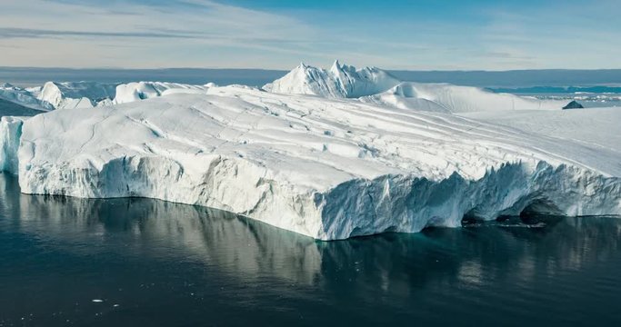 Iceberg aerial drone video - Global warming and climate change concept. Giant icebergs in Disko Bay on greenland in Ilulissat icefjord from melting glacier Sermeq Kujalleq Glacier, Jakobhavns Glacier.