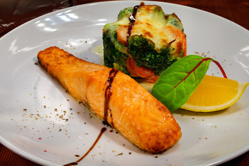 Salmon fillet with appetizing vegetable gratin under cheese