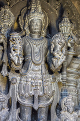 Fototapeta na wymiar Belur, Karnataka, India - November 2, 2013: Chennakeshava Temple building. Closeup of Whitened Black stone well-preserved sculpture of Lord Vishnu or here called Kesava in full regalia.