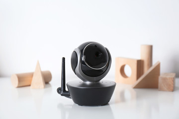 Modern CCTV security camera and wooden blocks on table