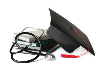 Stack of student textbooks, graduation hat and stethoscope on white background. Medical education