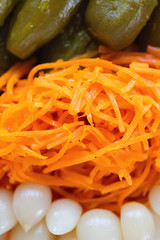 Assorted pickled and fermented vegetables in a white plate on a brown wooden background.