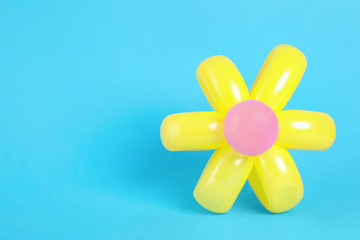 Flower figure made of modelling balloon on color background. Space for text