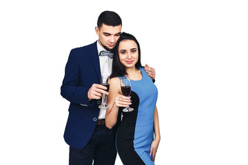young happy stylish couple in blue clothes posing with glasses of wine