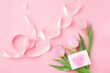 Bouquet of tulips on a pink pastel background. Wonderful spring breakfast on Mother's Day or Women. Flat lay. View top. Selective focus.