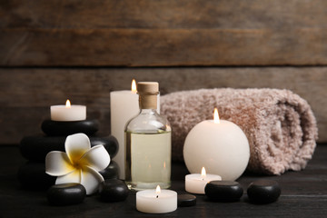 Spa composition with candles on wooden table