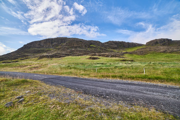 gravel dirt road in mountain landscape blue sky