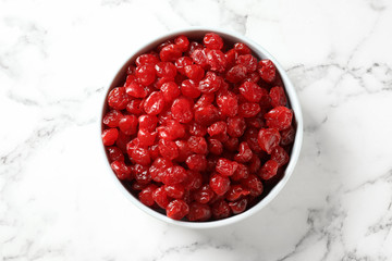 Bowl of sweet cherries on marble background, top view. Dried fruit as healthy snack