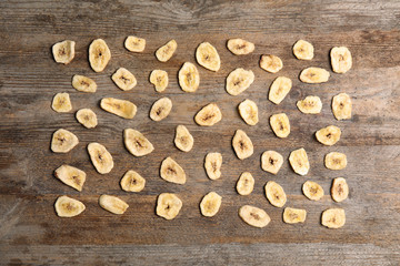 Flat lay composition with banana slices on wooden table. Dried fruit as healthy snack