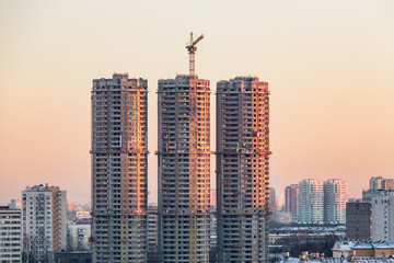 Fototapeta na wymiar Construction of high-rise residential buildings in the big city. Winter cityscape at sunset. Moscow, Russia