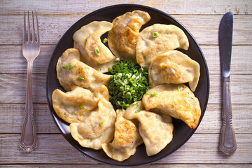 Fried dumplings stuffed with meat and served with chopped parsley and spring onion. overhead, horizontal