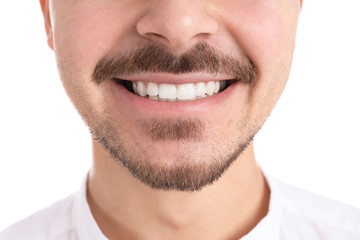 Young man with healthy teeth smiling on white background, closeup