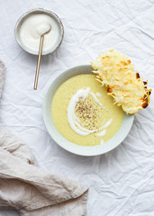 Potato cauliflower soup puree with vegan cheese snack on a white background, top view. Vegetarian healthy food concept