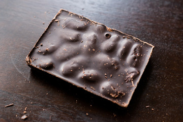 Bitter Almond Chocolate Bar on Dark Wooden Surface.