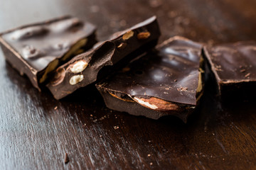 Bitter Almond Chocolate Pieces on Dark Wooden Surface.