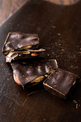 Bitter Almond Chocolate Pieces on Dark Wooden Surface.