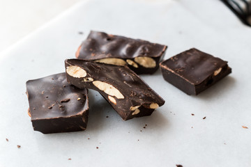 Bitter Almond Chocolate Pieces on White Marble Surface.