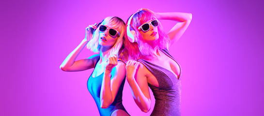 Fashion. Two DJ girl with Dyed Hair in Colorful neon light enjoy music, friends. Party disco 80s 90s vibes. Model woman in fashionable bodysuit, makeup. Creative art banner - obrazy, fototapety, plakaty