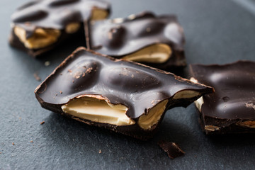 Bitter Almond Chocolate Pieces Dark Marble Surface.