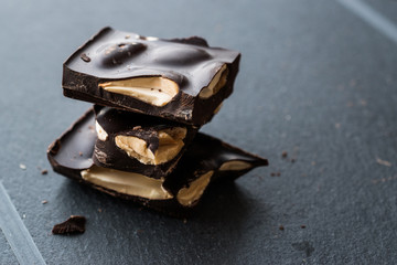 Bitter Almond Chocolate Pieces Dark Marble Surface.