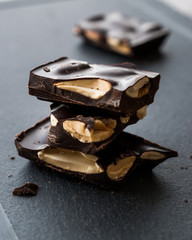 Bitter Almond Chocolate Pieces Dark Marble Surface.