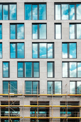 Obraz premium modern office building facade front partly, with scaffolding