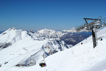 Fototapeta premium Skiers and snowboarders on chairlift, ski resort Rosa Khutor, Sochi Russia