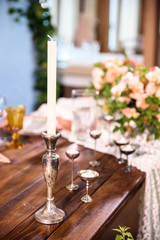 White candles in metal candle holders on a wooden table