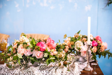 Festive table for two decorated with vintage lace, candles and flowers