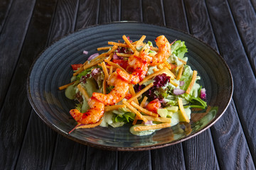 Shrimps on skewer with salad, avocado, tomato and pita chips