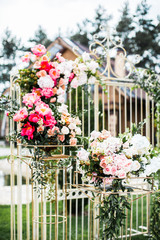 outdoor wedding ceremony. wedding arch in the form of gates decorated with greens and peonies flowers