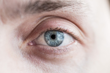 blue male eye looking into the lens