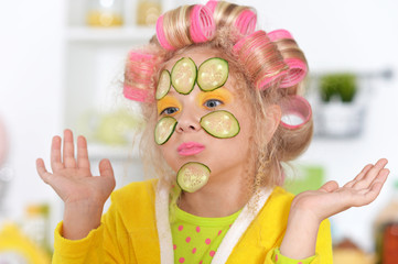 Happy cute little girl with hair curlers