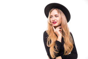 Portrait of young blonde woman in black floppy hat thinking isolated on white background