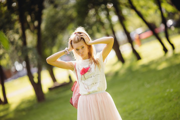 Positive and cute blond girl posing at the park