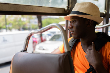 Profile view of young black African tourist man in bus