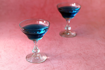 Blue curacao alcohol coctail on a pink background