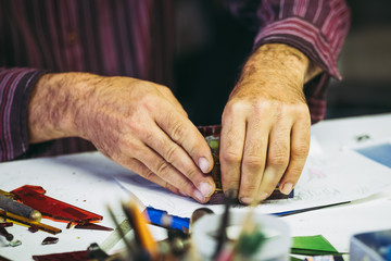 Mains d'un artisan en train de fabriquer une pièce en verre