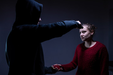 Ein Mann mit Pistole nimmt Geld von einer Frau